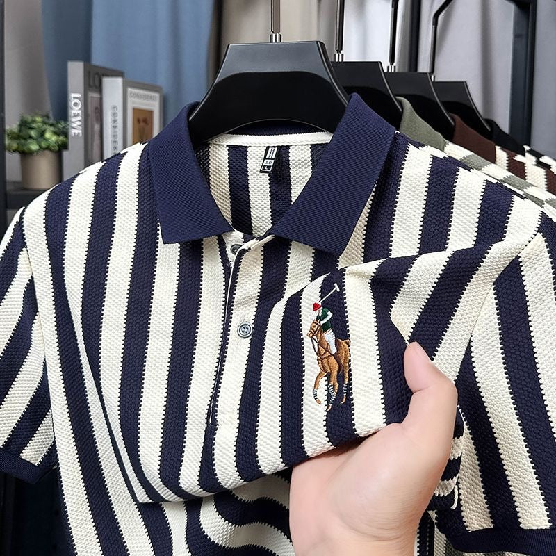 Navy and white striped polo shirt with embroidered logo on a hanger.